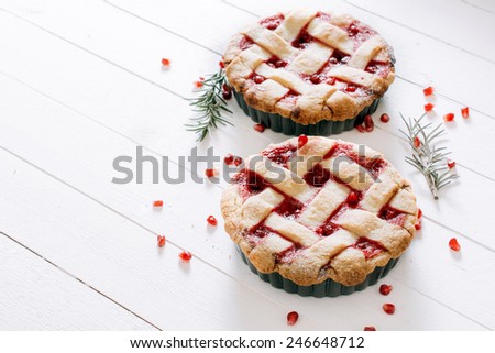 Sweet tart cake stuffed with pomegranate jam on wooden background with blank space