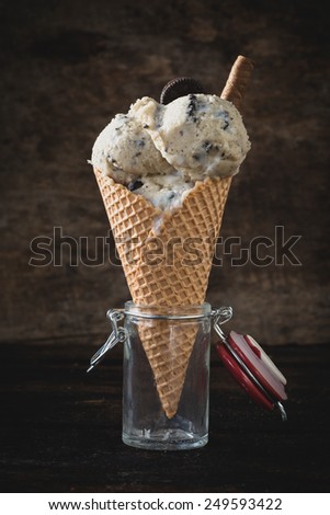 Ice cream with cookies in jar on wooden background