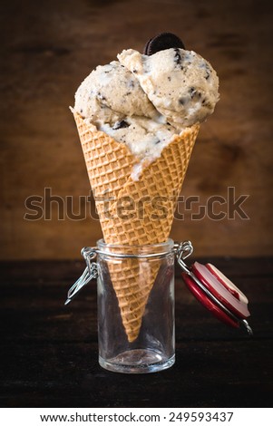 Ice cream with cookies in the jar on wooden background