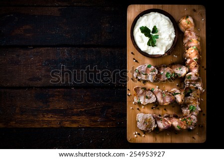 Served beef fillets and cream cheese on the wooden board with blank space