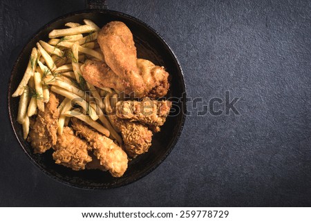 Fried chicken and French fries in the pan from above,blank space