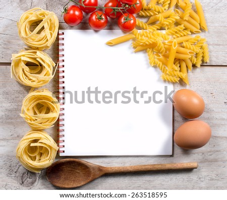 Blank cook book with set up for preparing traditional Italian cuisine,above and wooden background
