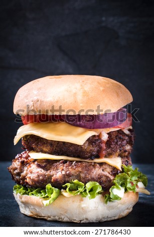 Double beef burger with cheese and vegetables,blank space and selective focus