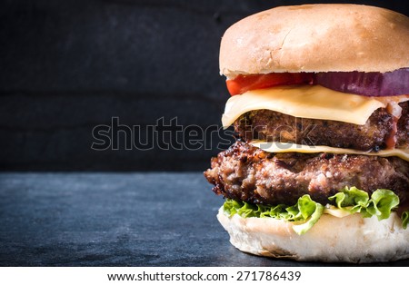 Double beef cheeseburger with vegetables,selective focus and blank space