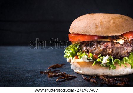 Messy homemade burger with cheese and vegetables,selective focus and blank space