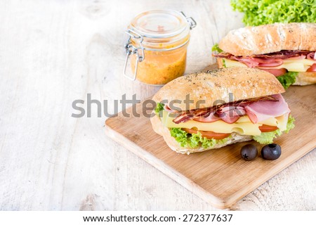 Two ciabatta sandwiches with meat and cheese on wooden board,selective focus and blank space