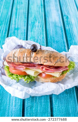 Served ciabatta sandwich stuffed with meat and cheese,selective focus