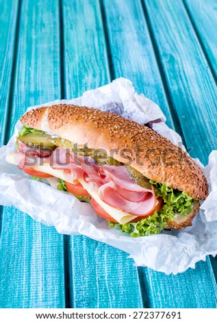 Served submarine sandwich stuffed with meat and cheese,selective focus