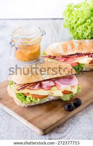 Ciabatta sandwichs with bacon and cheese on wooden boarde,selective focus
