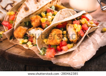 Tortilla bread stuffed with fried chicken meat and vegetables,selective focus