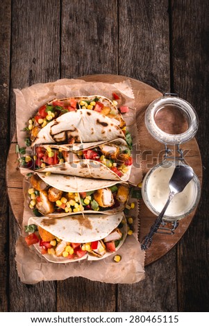Tortilla wrap sandwiches with fried chicken and vegetables from above on wooden background,selective focus and blank space
