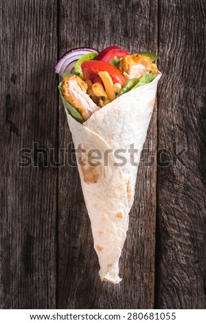 Chicken wrap sandwich on wooden background