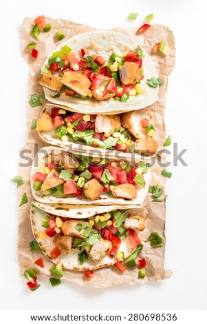 Tortilla wrap sandwich with fried chicken meat and vegetables from above