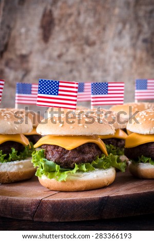 Mini beef burgers with American flag on wooden background,selective focus and blank space