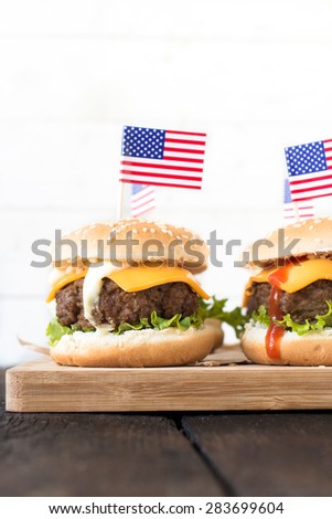 Mini beef burgers with American flag on wooden board,selective focus and blank space