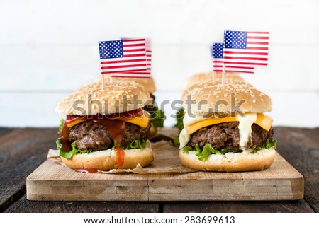 American mini beef burgers with cheese and USA flags on wooden board,selective focus
