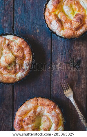 Mini cheese pies on wooden background from above