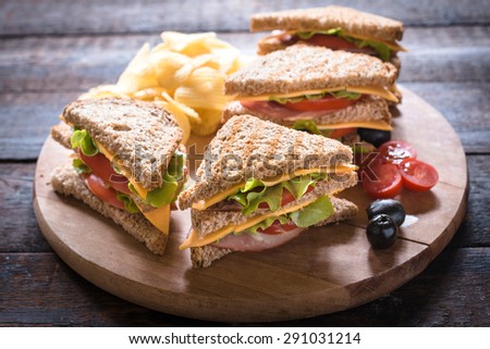 Group of club sandwiches with potato chips on wooden background,selective focus