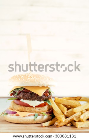 Beef burger and french fries on wooden board,selective focus and blank space