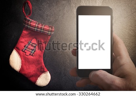 Traditional Christmas sock for presents on dark background with blank space on cell phone