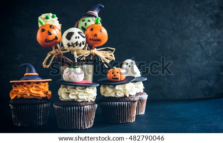 Funny delicious cake pops and cup cakes for Halloween on the table,selective focus and empty space