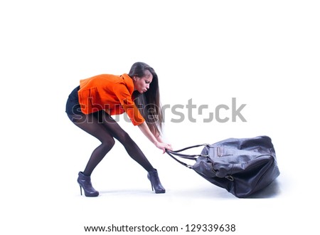 Beautiful woman carrying heavy bag  with some difficulty