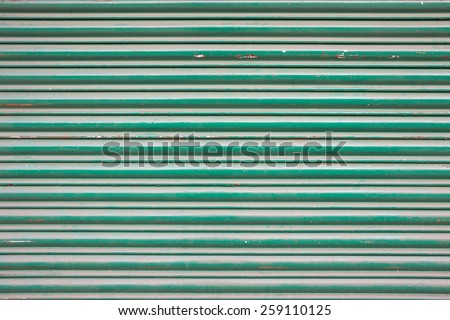 Large green metallic tin stripy fence background with scratches.