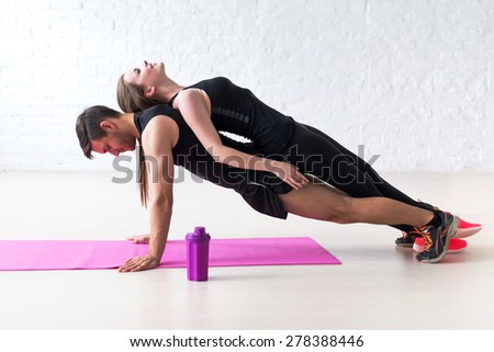 man doing push ups with woman laying on back at gym or home concept fitness sport training teamwork and lifestyle