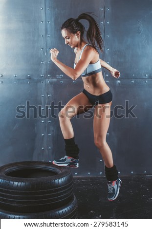 Sporty active fit woman box jumping. Female athlete is performing tire jumps fitness, sport, training and lifestyle concept