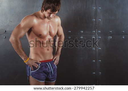 Portrait of fit athletic muscular shirtless young man looking down Fitness sport training lifestyle bodybuilding concept