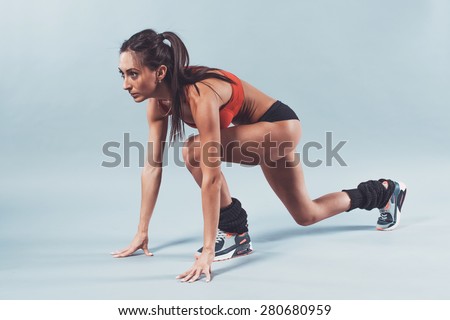 Sportive athlete woman sprinter waiting for the start running position fitness, sport, training and lifestyle concept.