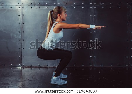 Athletic young woman fitness model warming up doing squats exercise for the buttocks concept sport slimming healthy lifestyle.
