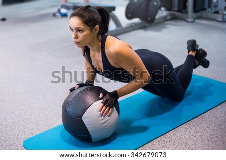 Fit woman exercising with medicine ball workout out arms Exercise training triceps and biceps doing push ups.