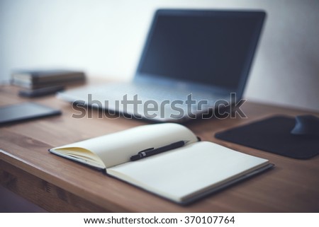 Stylish freelancer workspace with laptop open notepad work tools at home or studio office workplace