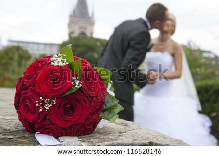 bride and gloom kissing.  beautiful red roses. wedding flowers bouquet. selective focus