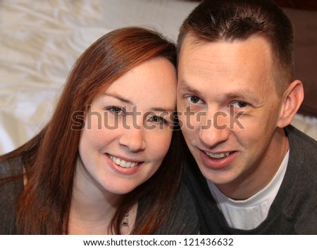 horizontal orientation of a happy, smiling couple with reddish hair and neutral background with copy space / So Happy Together