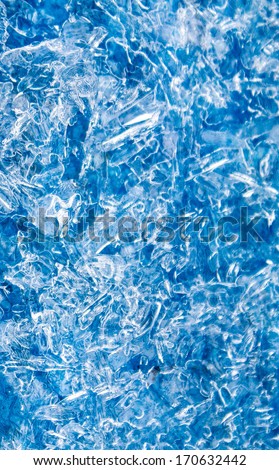 vertical orientation close up of ice formation on a textured surface creating an abstract background with copy space / Vertical Ice Pattern on Blue Surface