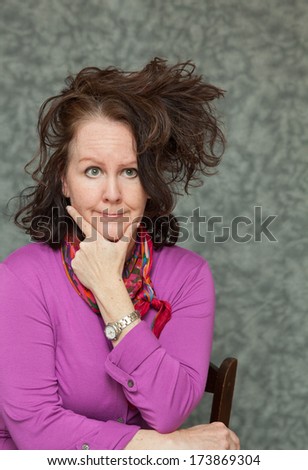 vertical orientation of a woman in brightly colored business attire with a questioning look on her face and a crazy hair style with neutral background / Time to Update my Style?