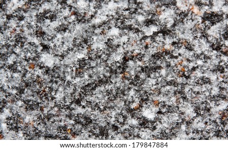 horizontal orientation extreme close up of snow covering a textured surface with a neutral background color / Snowflakes on a Patterned Surface