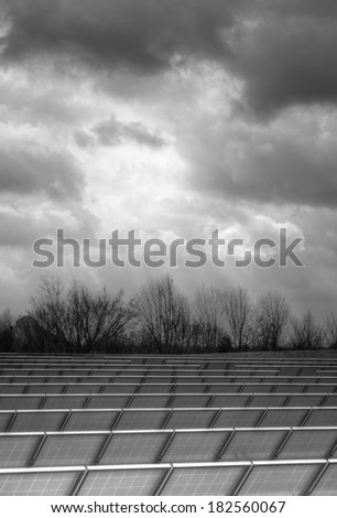 vertical orientation of solar panels in a field on a cloudy day in Black and White with High Dynamic Range (HDR) detail and copy space / Solar Panels on a Cloudy Day