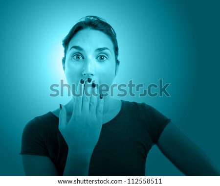 Young  woman portrait with her hand over her mouth tinted in blue