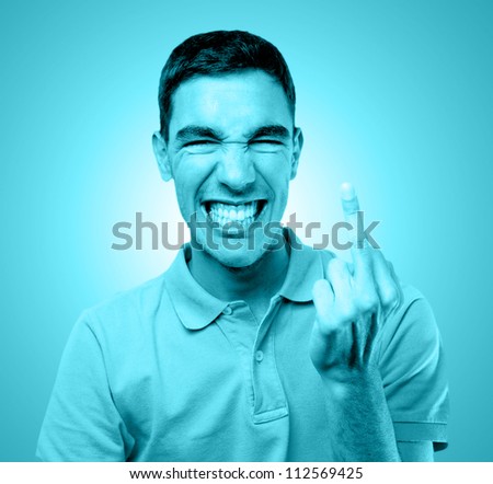 Young man doing an obscene gesture with his finger tinted in blue