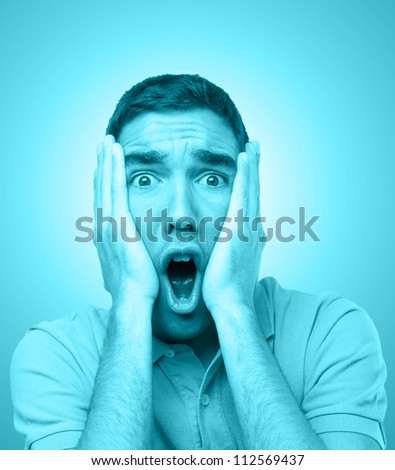 Young man looking scared tinted in blue