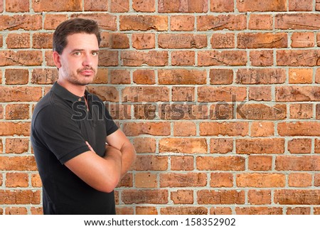 Confident young man over a bricks wall