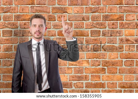Young business man pointing up with his finger
