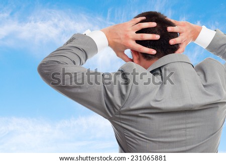 Business man over clouds background. Looking surprised
