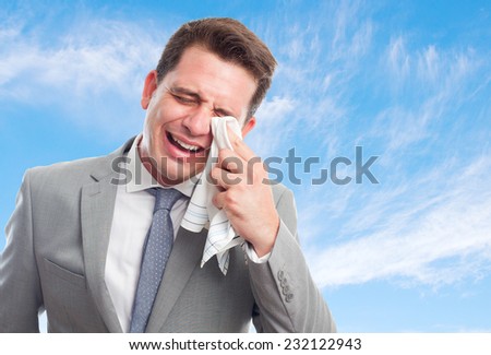 Young business man with grey suit over clouds background. Looking sad