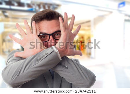 Business man over shopping center background. Looking scared