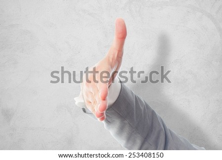 Business man with grey suit hand. It is doing the checking hands gesture. Over concrete wallpaper