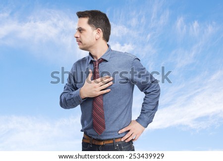 Man wearing a blue shirt and red tie. He is looking surprised. Over clouds background